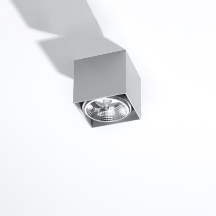 Plafonnier carré gris en aluminium, spot cube en saillie vu de trois quarts sur fond clair