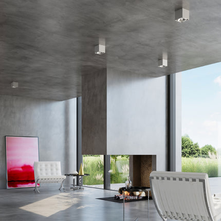 Plafonniers carrés gris au plafond béton d'un séjour design ouvert sur le jardin