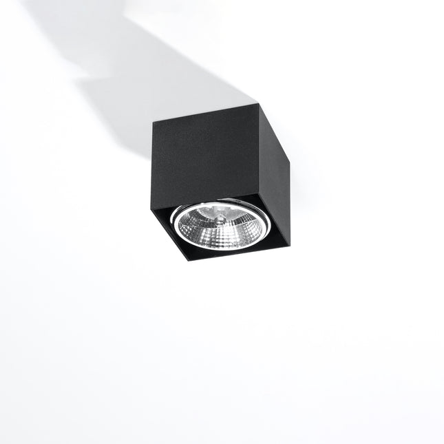 Plafonnier carré noir en aluminium, spot cube en saillie vu de trois quarts sur fond clair