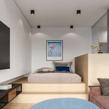 Plafonniers circulaires noirs allumés dans une chambre contemporaine, faisceaux doux sur le mur
