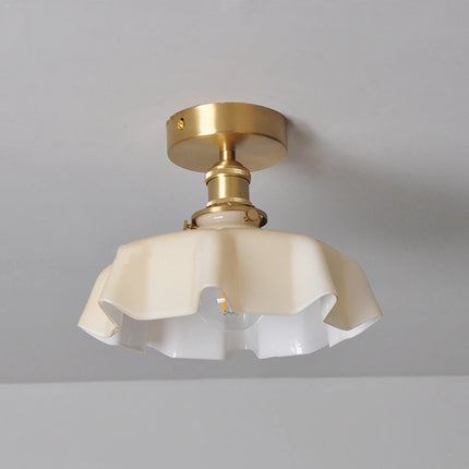 Détail du plafonnier corolle en verre blanc laiteux festonné et douille apparente en cuivre
