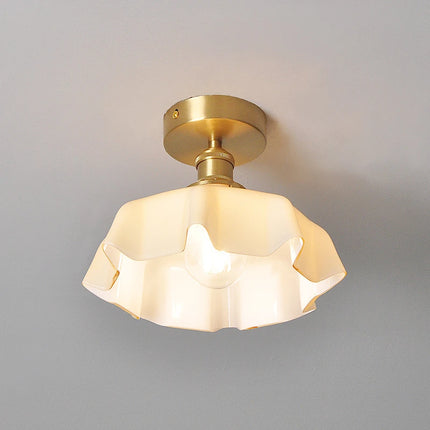 Plafonnier corolle en verre crème allumé, ambiance douce et lumière tamisée au plafond