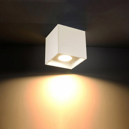 Plafonnier Cube LED beige clair allumée, faisceau net sur le mur