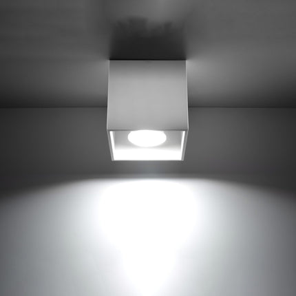 Plafonnier cube LED blanc projetant un faisceau de lumière net