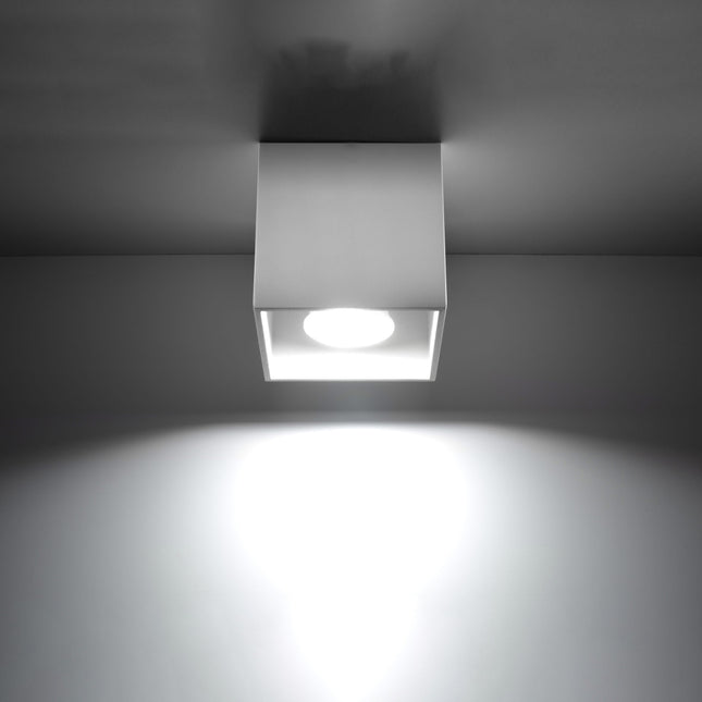 Plafonnier cube LED blanc projetant un faisceau de lumière net
