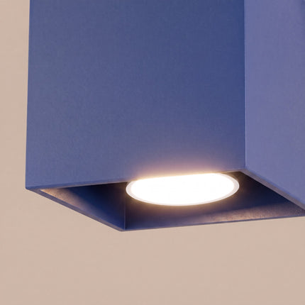 Plafonnier Cube LED bleu outremer sur fond coloré, vue de trois quarts