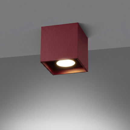 Plafonnier Cube LED bordeaux allumée, faisceau net sur le mur