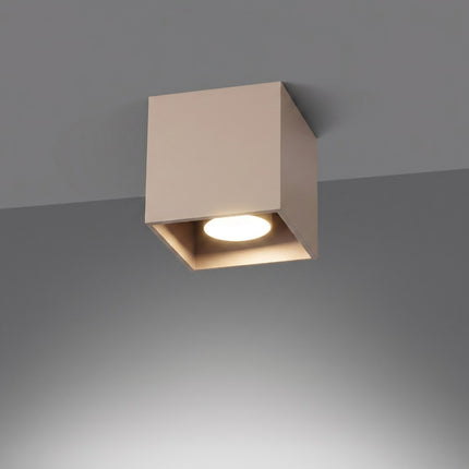 Plafonnier Cube LED taupe allumée, faisceau net sur le mur
