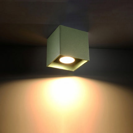 Plafonnier Cube LED vert olive allumée, faisceau net sur le mur