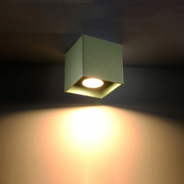 Plafonnier Cube LED vert olive allumée, faisceau net sur le mur