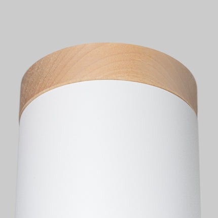Plafonnier cylindre blanc et bois naturel diffusant une lumière douce en chambre