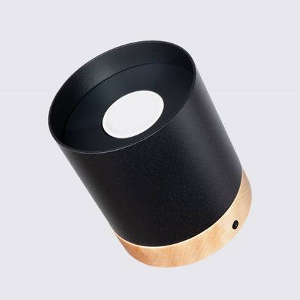 Plafonnier cylindre noir et bois naturel diffusant une lumière douce en chambre