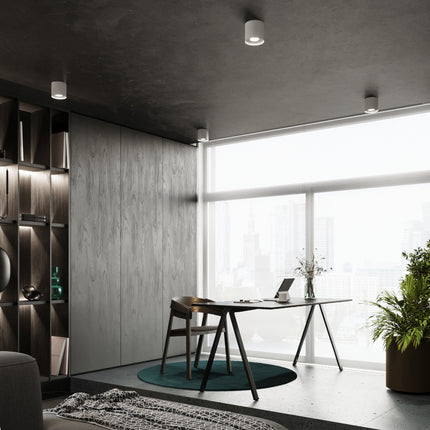 Plafonniers blancs disposés au plafond d'une chambre au décor épuré