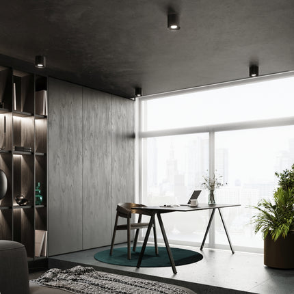 Plafonniers noirs disposés au plafond d'une chambre au décor épuré