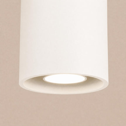 Plafonnier Cylindre LED beige clair sur fond coloré, vue de trois quarts
