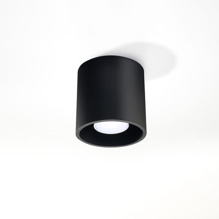 Plafonnier cylindre en aluminium noir mat installé dans un salon contemporain