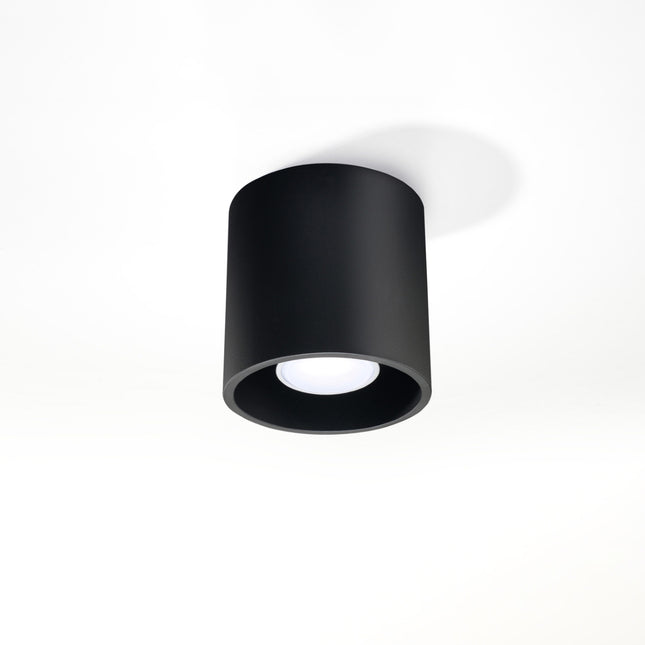 Plafonnier cylindre en aluminium noir mat installé dans un salon contemporain