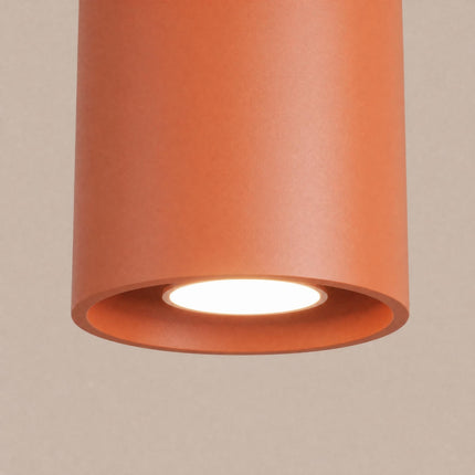 Plafonnier Cylindre LED ocre rouge sur fond coloré, vue de trois quarts