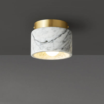 Plafonnier cylindre en marbre blanc veiné et collerette laiton doré, sur fond neutre