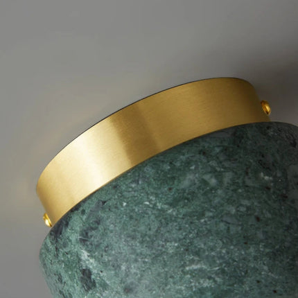 Détail de la collerette en laiton doré brossé du plafonnier cylindre en marbre vert