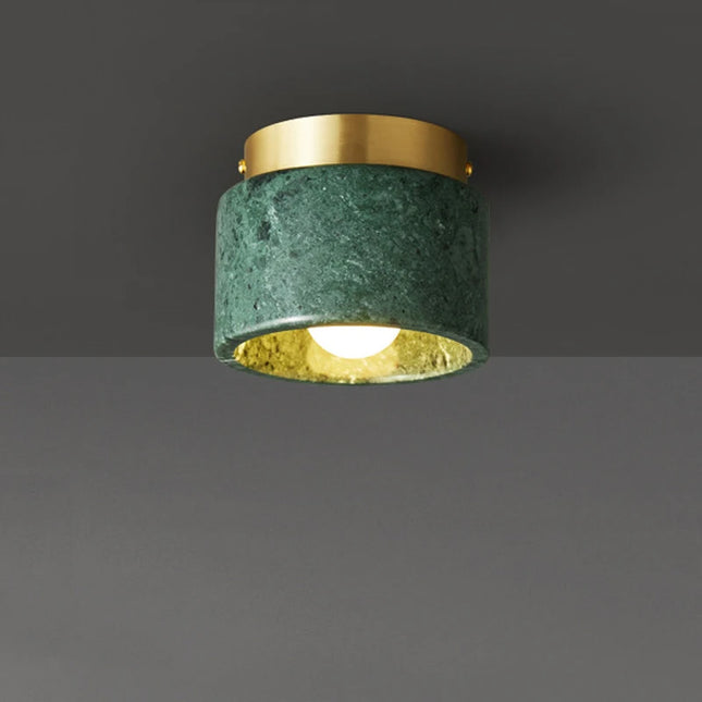 Plafonnier cylindre en marbre vert et collerette laiton, ampoule globe, sur fond neutre