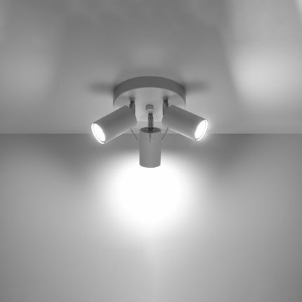 Plafonnier 3 spots blanc allumé au plafond, faisceau lumineux dirigé vers le sol
