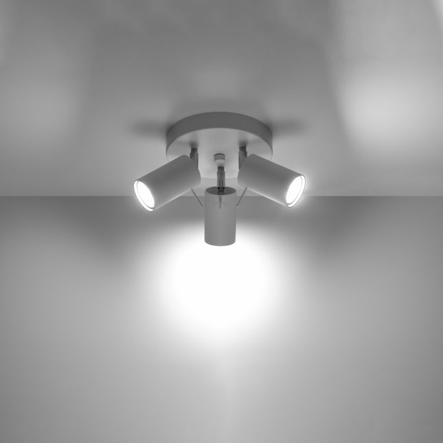 Plafonnier 3 spots blanc allumé au plafond, faisceau lumineux dirigé vers le sol