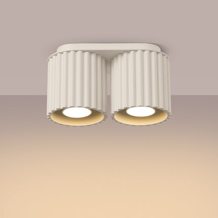 Plafonnier double Aura beige allumé au plafond, faisceau chaud dirigé vers le bas