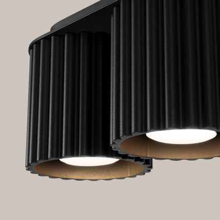 Détail des cylindres cannelés du plafonnier Aura noir mat avec réflecteur intérieur