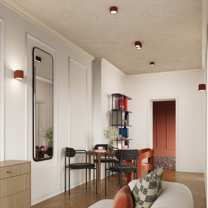 Plafonnier double Aura rouge ocre au plafond d'un coin repas aux murs clairs et parquet