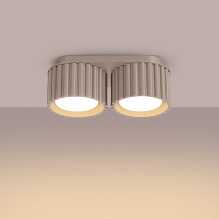 Plafonnier double Aura taupe allumé au plafond diffusant une lumière chaude vers le bas