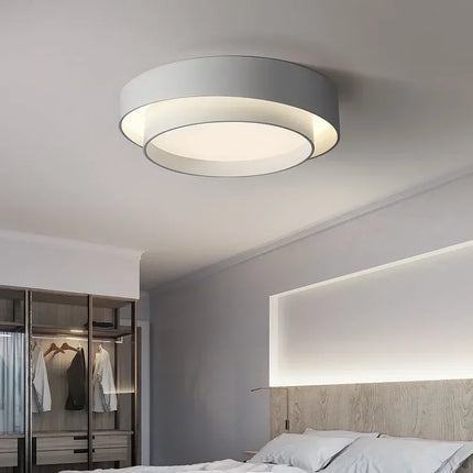 Plafonnier LED double cercle blanc dans une chambre au dressing vitré