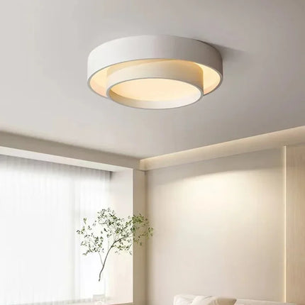 Plafonnier LED double cercle blanc allumé dans un salon lumineux