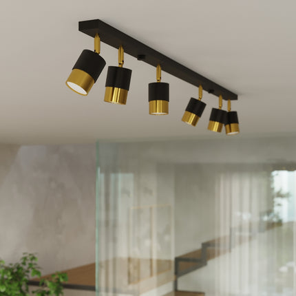 Détail des plafonniers Double Cylindre noir et doré allumés au plafond d'un salon contemporain