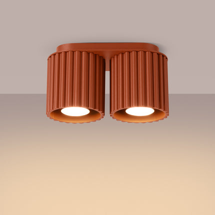 Plafonnier double spot Aura rouge ocre allumé, faisceau chaud dirigé vers le bas