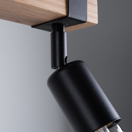 Détail du mécanisme orientable d'un spot du plafonnier Élégance Bois Noir, articulation en métal noir sur bois