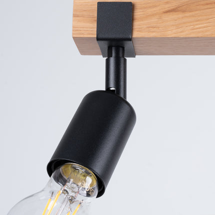 Détail du mécanisme orientable d'un spot du plafonnier Élégance Bois Noir, articulation en métal noir sur bois