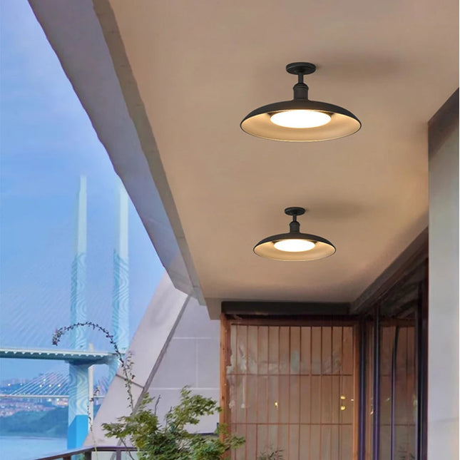 Deux plafonniers extérieurs noirs LED au plafond d'un balcon couvert au crépuscule