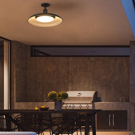 Plafonnier extérieur noir LED éclairant une cuisine extérieure avec barbecue