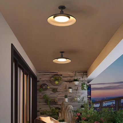 Plafonniers extérieurs noirs LED éclairant une terrasse abritée avec mur végétal