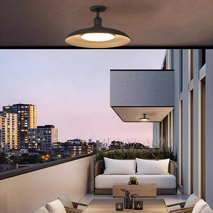 Plafonnier extérieur noir LED au-dessus d'un salon de terrasse en rooftop au coucher du soleil