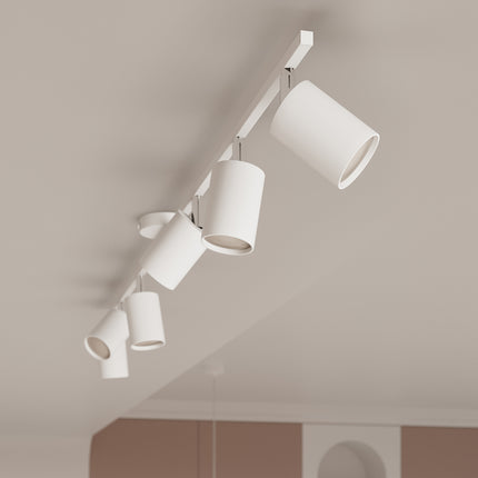 Plafonnier à spots orientables blanc installé sur un plafond incliné, éclairage dirigé en plusieurs points