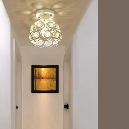 Plafonnier globe en cristal blanc éclairant un couloir orné d'un tableau