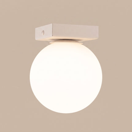 Plafonnier Globe Solis 1 globe beige sur fond coloré, vue de trois quarts