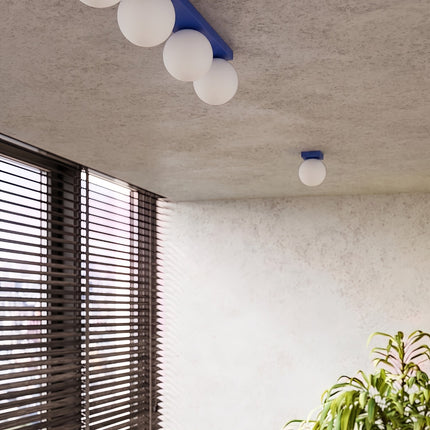 Plafonnier Globe Solis 1 globe bleu outremer dans une pièce claire à stores en bois
