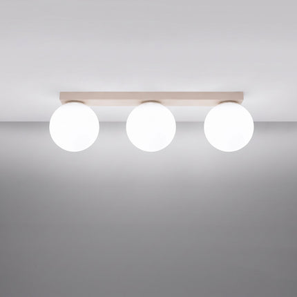 Plafonnier Globe Solis 3 globes beige allumé, halo doux du verre opalin