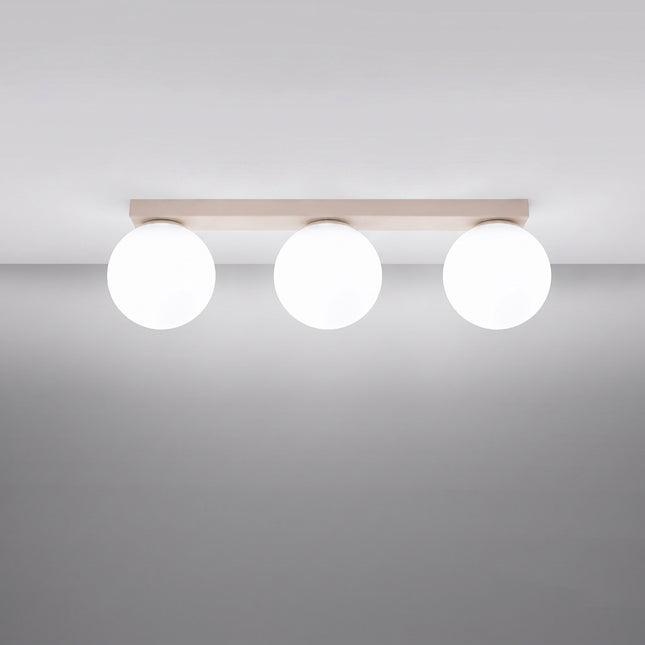 Plafonnier Globe Solis 3 globes beige allumé, halo doux du verre opalin