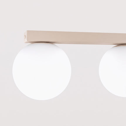 Plafonnier Globe Solis 3 globes beige sur fond coloré, vue de trois quarts