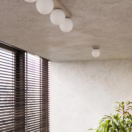 Plafonnier Globe Solis 3 globes taupe dans une pièce claire à stores en bois