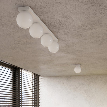 Gros plan sur les globes en verre opale blanc d'un plafonnier Globe Solis fixé au plafond